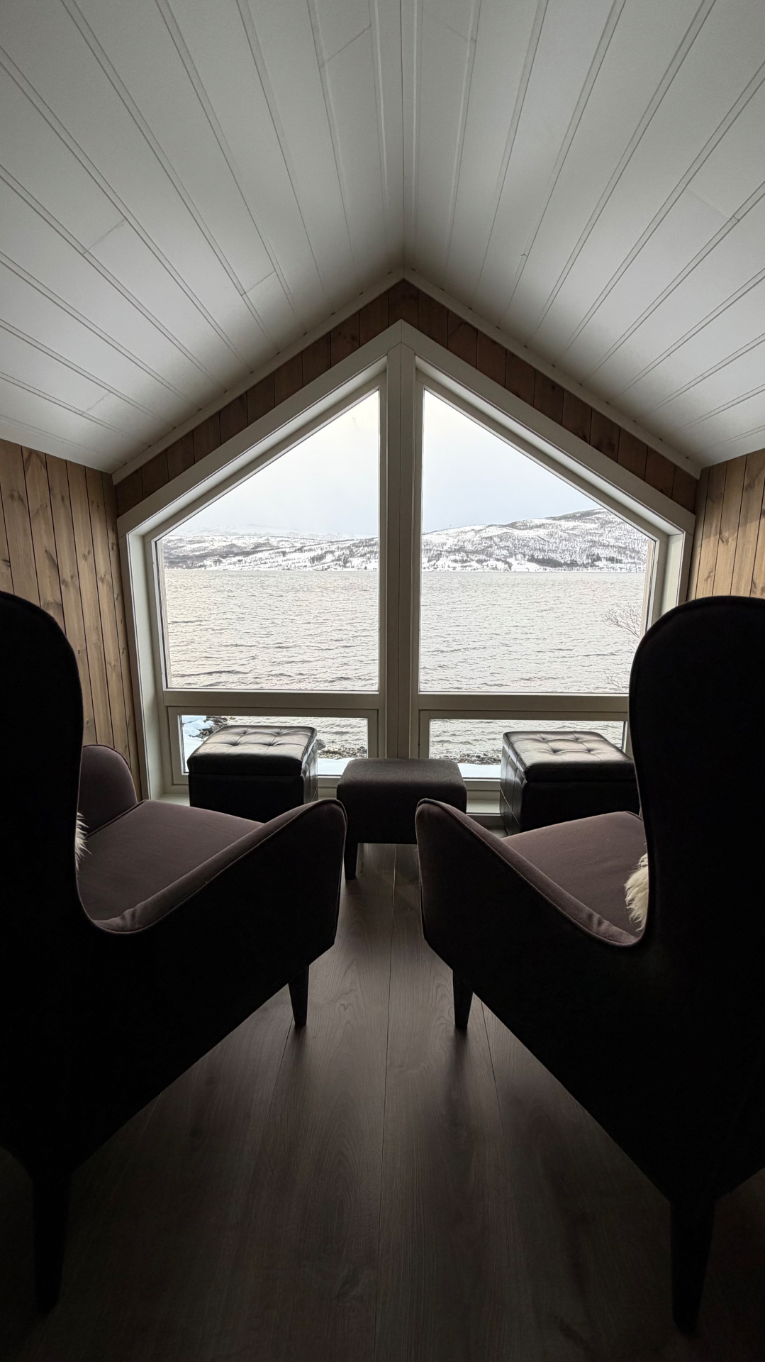 Fensternische mit Sesseln und Blick auf die verschneiten Berge