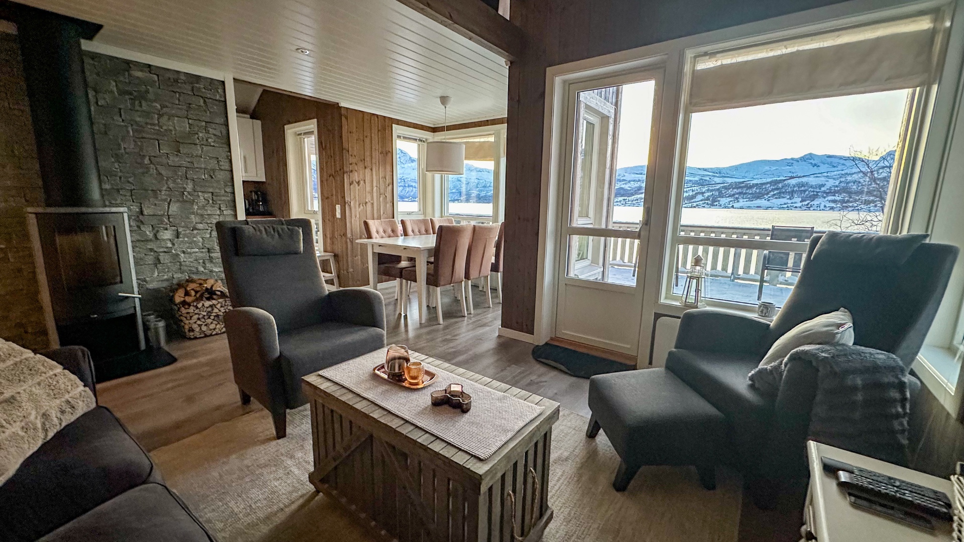 Wohnzimmer mit Kamin und Blick auf Terrasse und Fjord