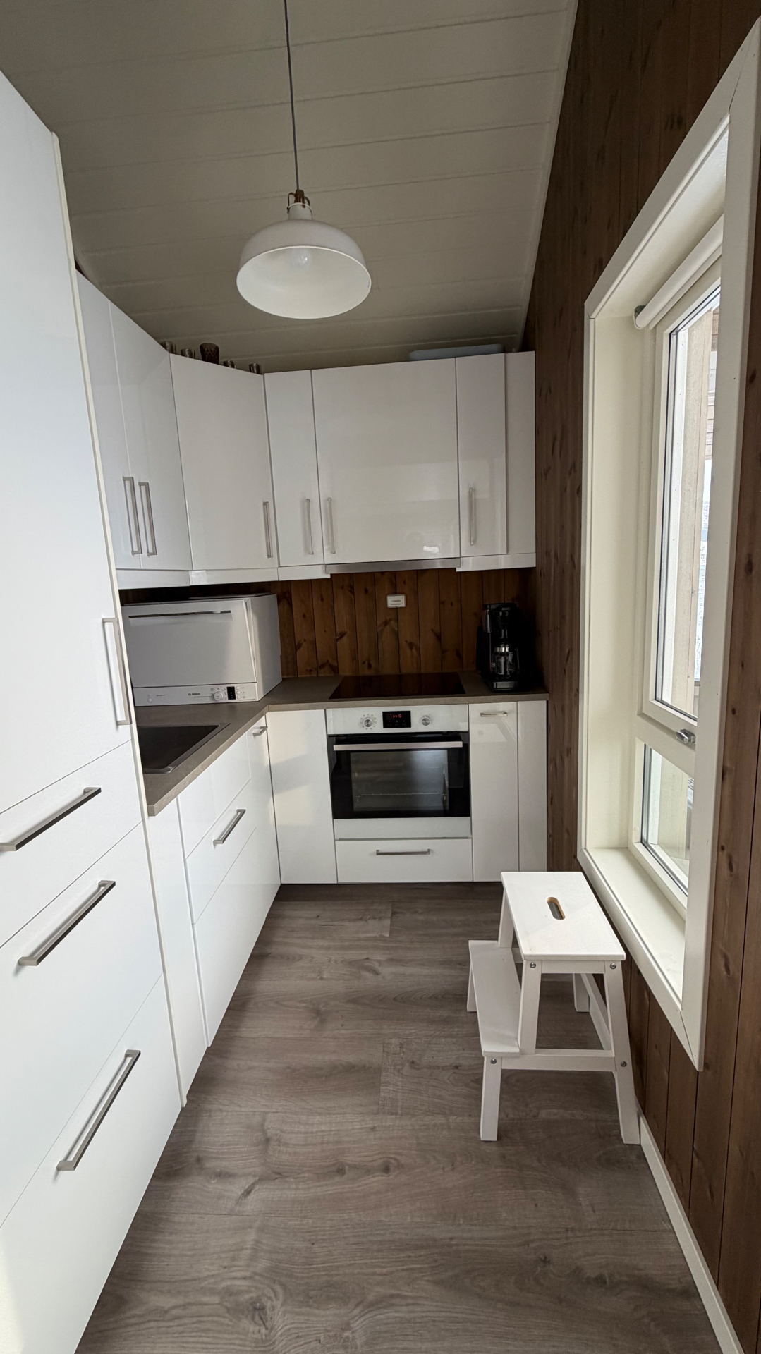 Küche mit Backofen, Induktionskochfeld, Spülmaschine und Kaffeemaschine