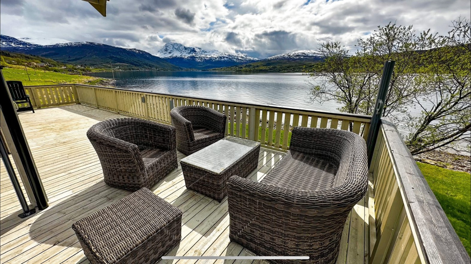 Sessel auf der Terrasse mit Blick auf den Fjord und die schneebedeckten Berge